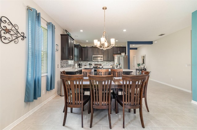 dining space with light tile patterned flooring, visible vents, baseboards, recessed lighting, and a chandelier