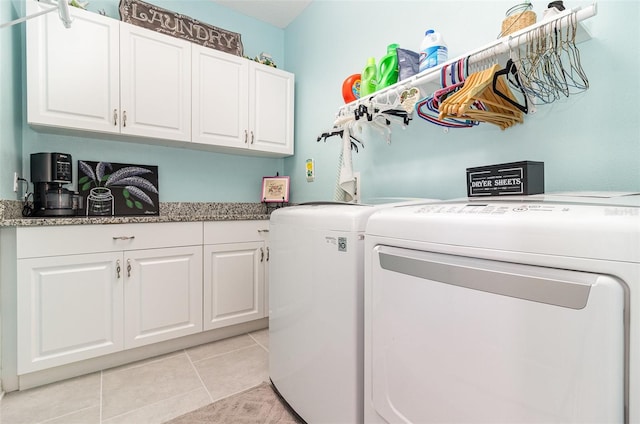 washroom featuring cabinet space, washer and clothes dryer, and light tile patterned flooring