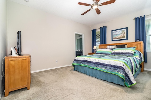 bedroom featuring ensuite bath, carpet flooring, baseboards, and ceiling fan