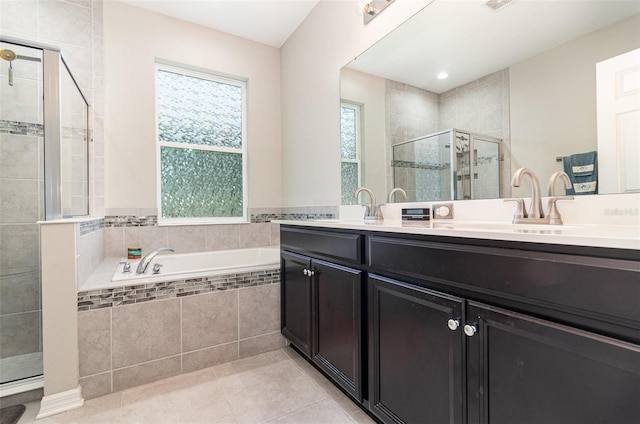 bathroom with a garden tub, a sink, tile patterned flooring, and a stall shower