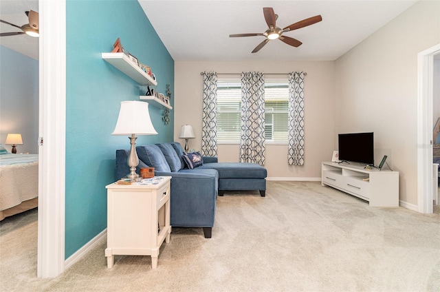 carpeted living room with a ceiling fan and baseboards