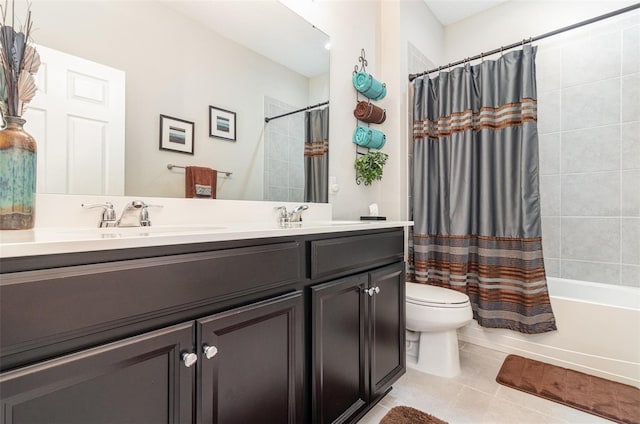 full bath featuring double vanity, tile patterned floors, a sink, and toilet