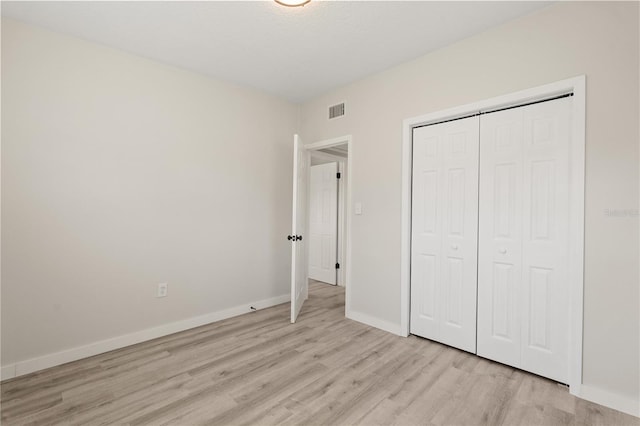 101 W Wallace St, Orlando, FL 32809 - unfurnished bedroom featuring a closet, baseboards, light wood-style floors, and visible vents
