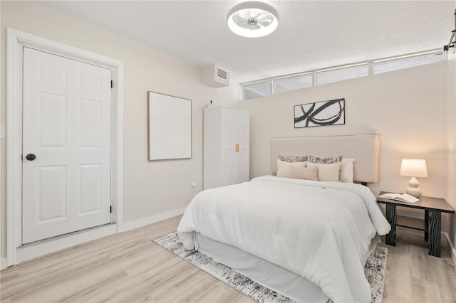 101 W Wallace St, Orlando, FL 32809 - bedroom featuring a textured ceiling, baseboards, light wood-style flooring, and visible vents