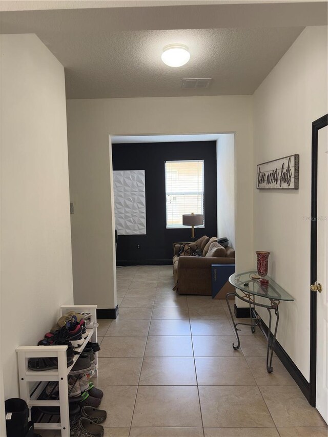 422 Janice Kay Pl, Kissimmee, FL 34744 - hall featuring baseboards, visible vents, a textured ceiling, and light tile patterned floors