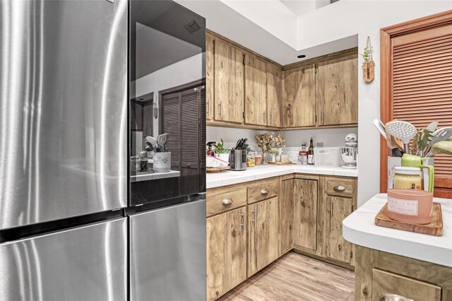 2475 Cox Rd, Cocoa, FL 32926 - kitchen featuring tile counters, light wood-style flooring, and smart refrigerator