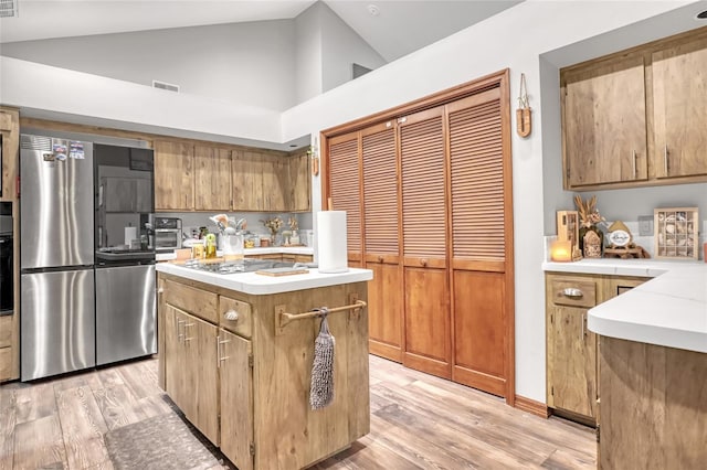 2475 Cox Rd, Cocoa, FL 32926 - kitchen featuring smart refrigerator, light countertops, gas cooktop, light wood-type flooring, and a center island