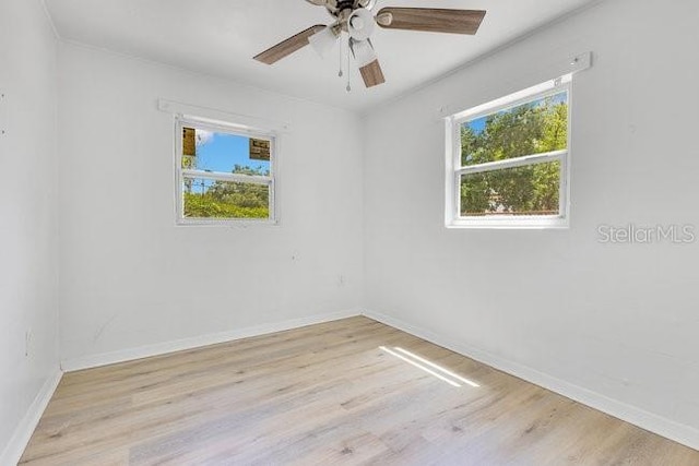 unfurnished room featuring wood finished floors, baseboards, and ceiling fan