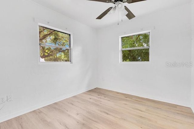 unfurnished room featuring plenty of natural light, light wood finished floors, baseboards, and a ceiling fan