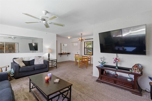 carpeted living room with ceiling fan with notable chandelier
