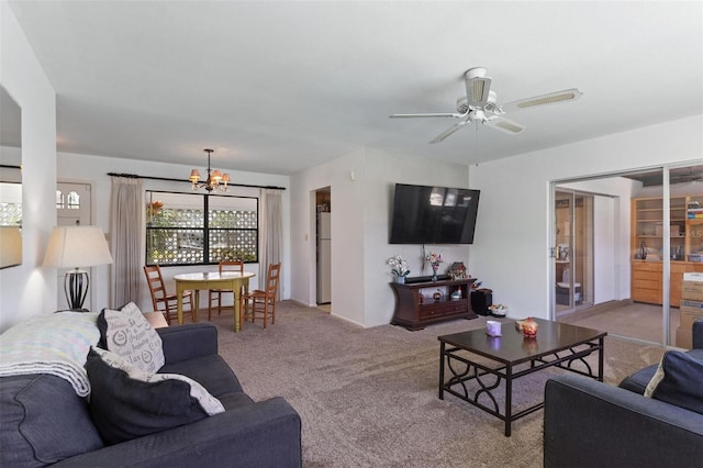 living room with carpet floors and ceiling fan with notable chandelier
