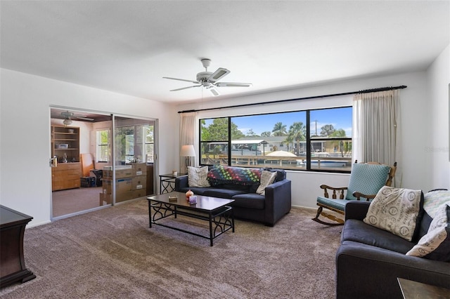 living area featuring a ceiling fan and carpet