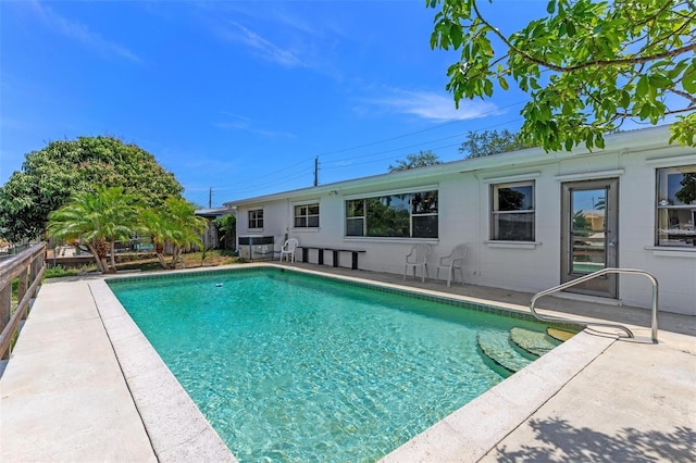 outdoor pool with a patio and fence