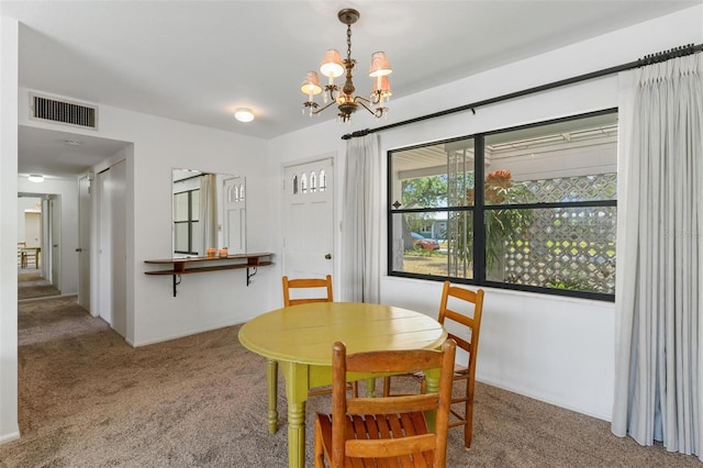 dining room with visible vents, carpet floors, and an inviting chandelier