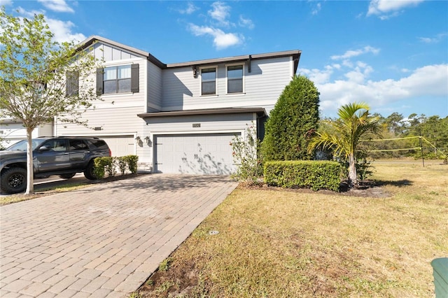 11150 Whistling Pine Way, Orlando, FL 32832 - traditional home with board and batten siding, a front yard, decorative driveway, and an attached garage
