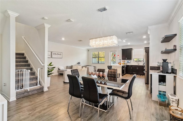 11150 Whistling Pine Way, Orlando, FL 32832 - dining area with a chandelier, crown molding, light wood finished floors, stairs, and recessed lighting