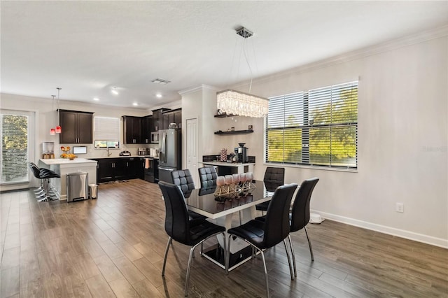 11150 Whistling Pine Way, Orlando, FL 32832 - dining room featuring baseboards, visible vents, ornamental molding, and wood finished floors
