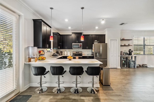 11150 Whistling Pine Way, Orlando, FL 32832 - kitchen featuring light countertops, wood finished floors, a peninsula, and appliances with stainless steel finishes