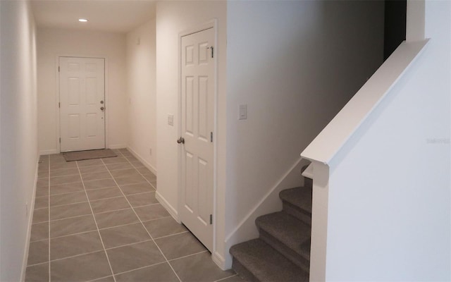 corridor with baseboards, stairs, recessed lighting, and light tile patterned floors