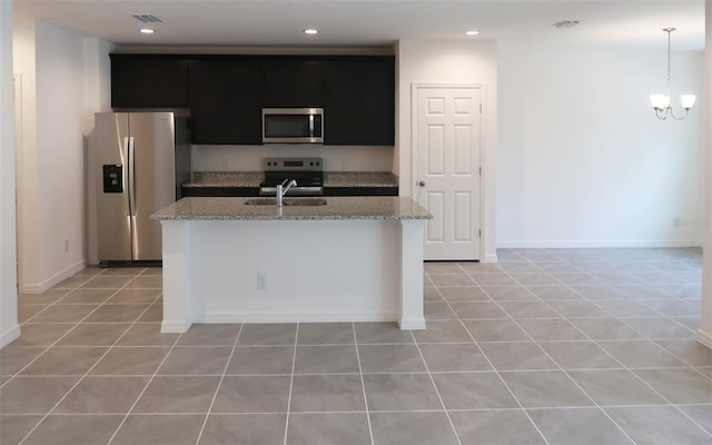 kitchen featuring a sink, stainless steel appliances, a kitchen island with sink, visible vents, and dark cabinets