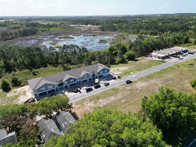 birds eye view of property featuring a water view and a view of trees