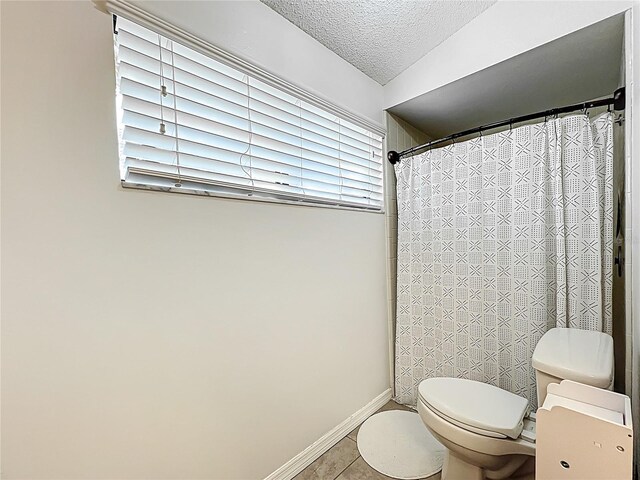 1007 Gammage Pt, Oviedo, FL 32765 - full bathroom featuring toilet, a textured ceiling, tile patterned flooring, baseboards, and a shower with curtain