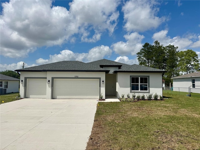 12950 SW 38th Cir, Ocala, FL 34473 - view of front of home with stucco siding, fence, an attached garage, driveway, and a front lawn
