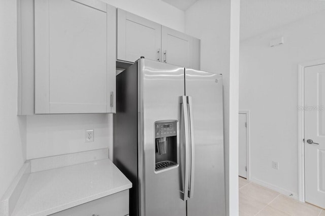 174 River Front Way, Edgewater, FL 32141 - kitchen with stainless steel refrigerator with ice dispenser, baseboards, and light tile patterned floors