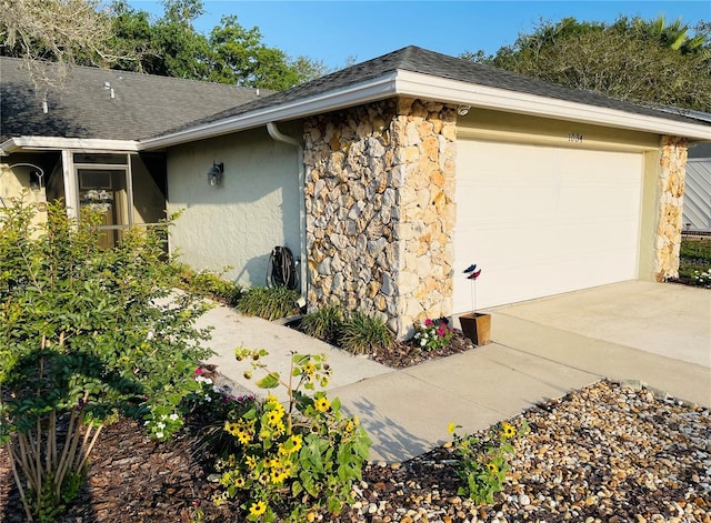 1034 Weathered Wood Cir, Winter Springs, FL 32708 - view of side of property featuring stone siding, stucco siding, driveway, a garage, and roof with shingles