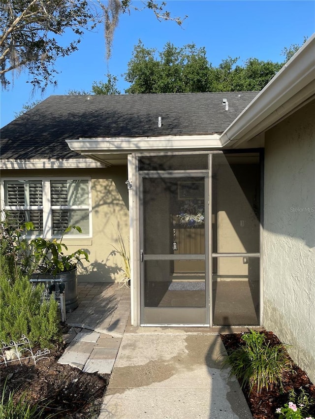 1034 Weathered Wood Cir, Winter Springs, FL 32708 - view of exterior entry featuring stucco siding, a shingled roof, and a patio area