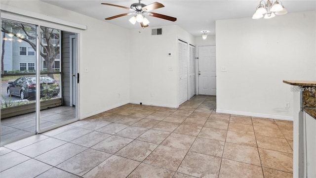 5962 Westgate Dr Unit 101, Orlando, FL 32835 - empty room featuring light tile patterned floors, ceiling fan with notable chandelier, baseboards, and visible vents
