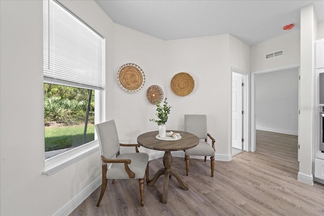 dining room featuring wood finished floors, visible vents, and baseboards
