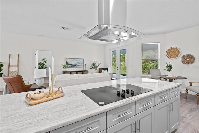 kitchen with exhaust hood, visible vents, french doors, light wood-type flooring, and black electric stovetop