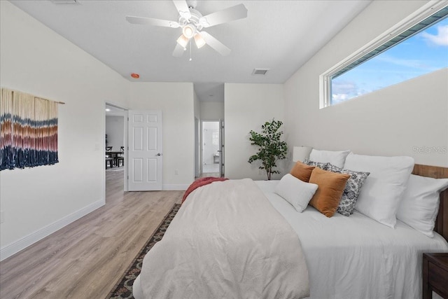 bedroom featuring wood finished floors, visible vents, a ceiling fan, and baseboards