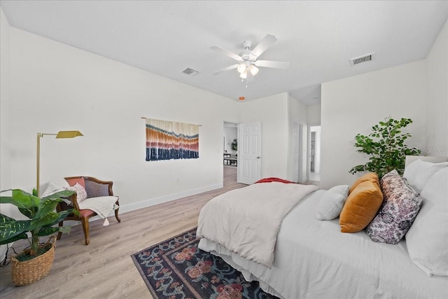 bedroom with wood finished floors, visible vents, a ceiling fan, and baseboards