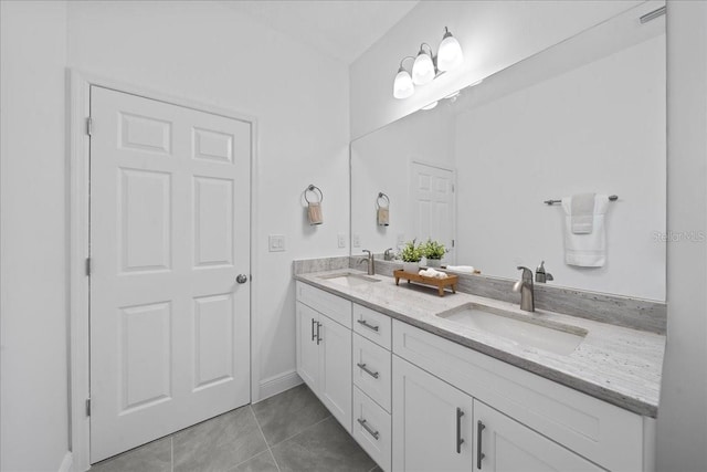 bathroom with double vanity, tile patterned flooring, baseboards, and a sink