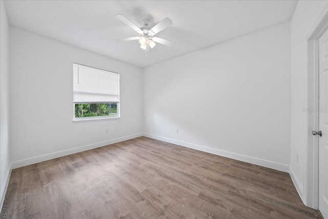spare room featuring baseboards, a ceiling fan, and wood finished floors
