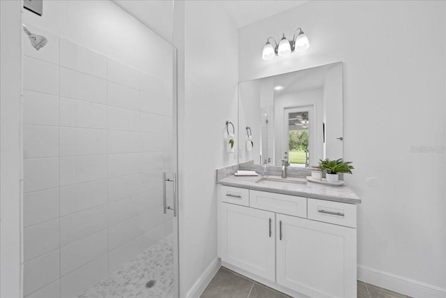 full bathroom with baseboards, vanity, and a stall shower
