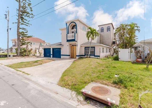 11120 5th St E, Treasure Island, FL 33706 - mediterranean / spanish-style house with a balcony, concrete driveway, stucco siding, and an attached garage