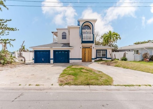 11120 5th St E, Treasure Island, FL 33706 - view of front of house featuring concrete driveway, a balcony, and stucco siding