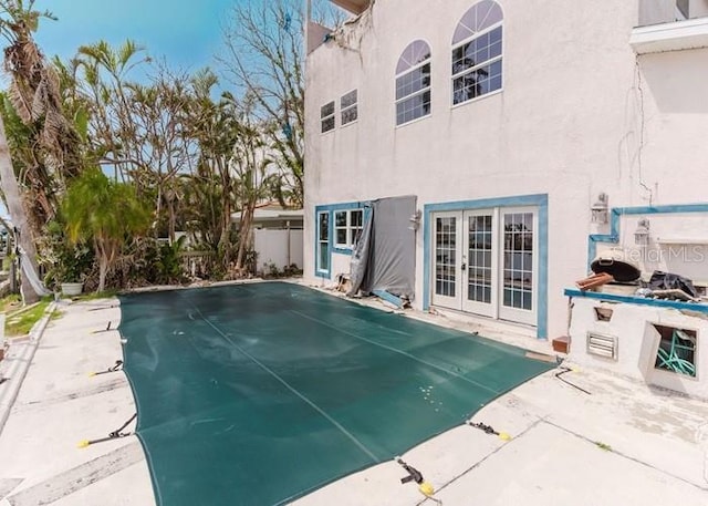 11120 5th St E, Treasure Island, FL 33706 - view of swimming pool with a covered pool, a patio area, and french doors