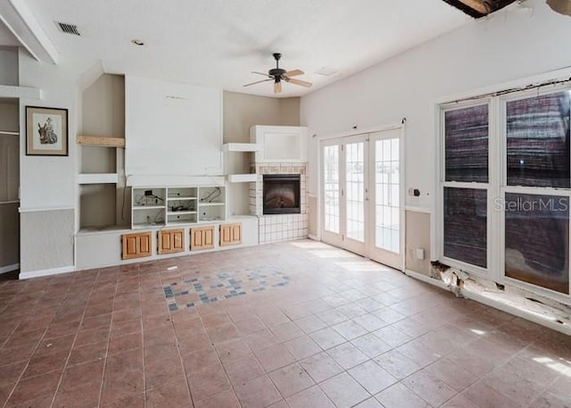 11120 5th St E, Treasure Island, FL 33706 - unfurnished living room featuring ceiling fan, a fireplace, built in features, and tile patterned floors