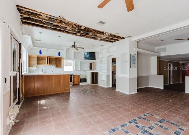 11120 5th St E, Treasure Island, FL 33706 - kitchen featuring ceiling fan, open floor plan, and brown cabinetry