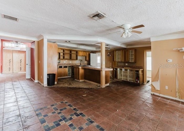 11120 5th St E, Treasure Island, FL 33706 - kitchen featuring brown cabinetry, ornamental molding, a ceiling fan, a textured ceiling, and light countertops