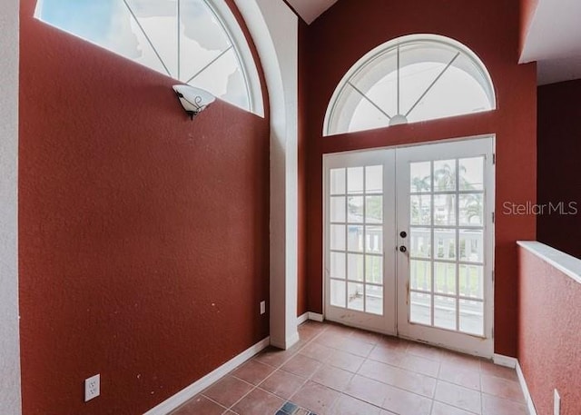 11120 5th St E, Treasure Island, FL 33706 - doorway featuring french doors, tile patterned flooring, and baseboards