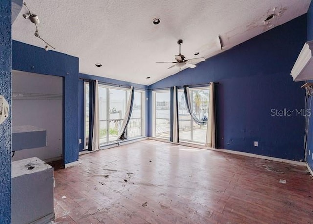 11120 5th St E, Treasure Island, FL 33706 - unfurnished room featuring vaulted ceiling, hardwood / wood-style floors, a ceiling fan, healthy amount of natural light, and a textured ceiling