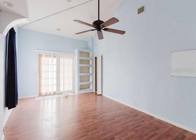 11120 5th St E, Treasure Island, FL 33706 - empty room with a ceiling fan, wood finished floors, baseboards, and vaulted ceiling