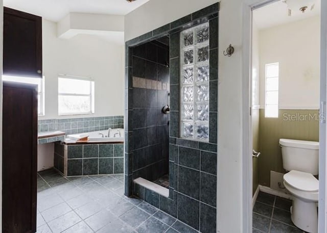 11120 5th St E, Treasure Island, FL 33706 - bathroom with tile patterned floors, a bath, toilet, and a walk in shower