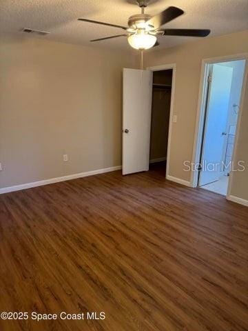 spare room with dark wood-style floors, visible vents, ceiling fan, and a textured ceiling