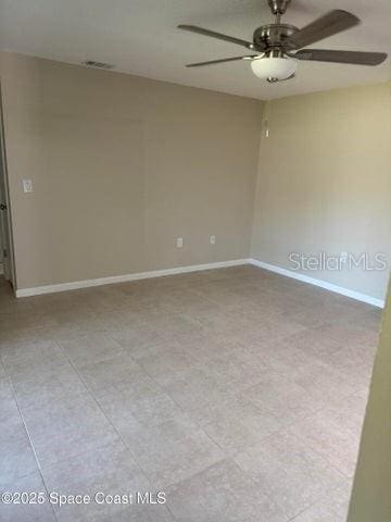 spare room featuring baseboards, visible vents, and a ceiling fan